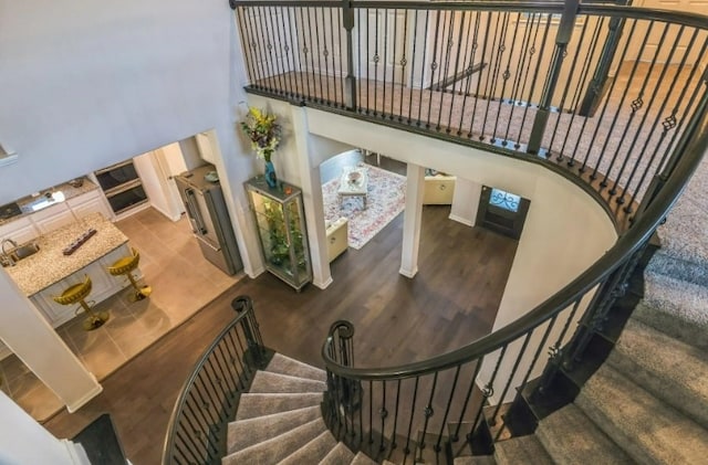 stairway featuring hardwood / wood-style floors and a towering ceiling