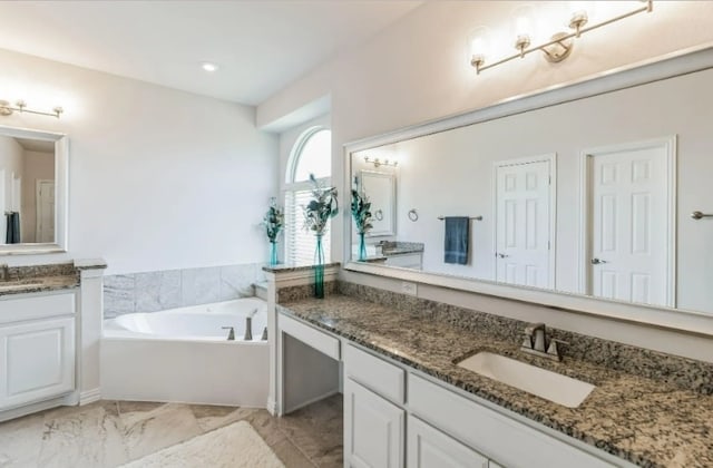 bathroom featuring a bath, tile patterned floors, and vanity