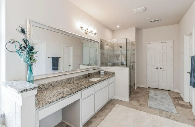 bathroom with tile patterned flooring, a shower with door, and vanity