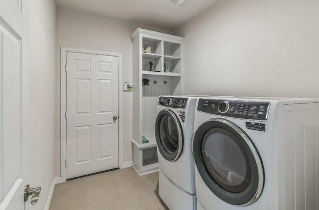 clothes washing area with washer and dryer and light tile patterned floors