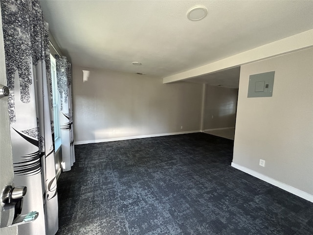 empty room featuring dark carpet and electric panel