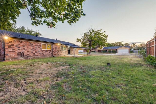 yard at dusk featuring a garage