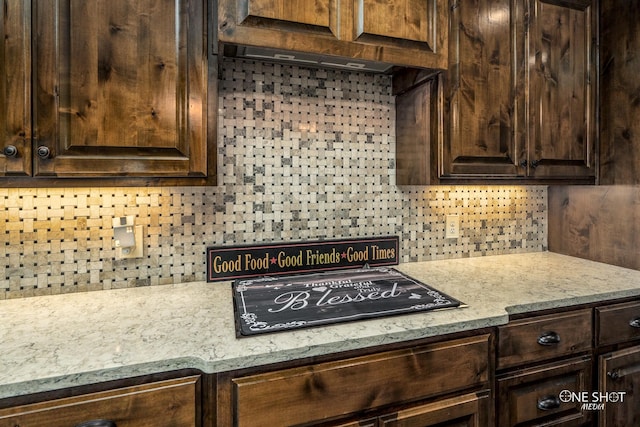 kitchen with decorative backsplash, dark brown cabinets, and black electric cooktop