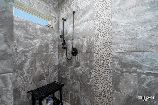 interior details featuring a tile shower