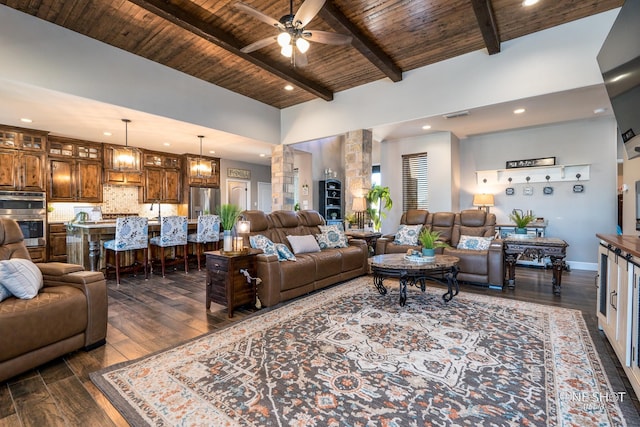 living room with beam ceiling, ceiling fan, dark hardwood / wood-style floors, a towering ceiling, and wood ceiling