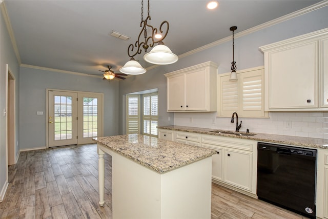 kitchen featuring backsplash, decorative light fixtures, sink, black dishwasher, and a kitchen island