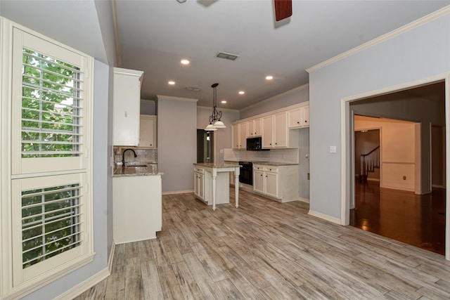 kitchen with pendant lighting, light stone counters, tasteful backsplash, and light hardwood / wood-style floors