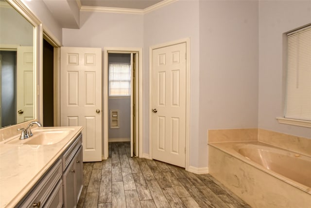 bathroom with ornamental molding, vanity, hardwood / wood-style flooring, and a washtub