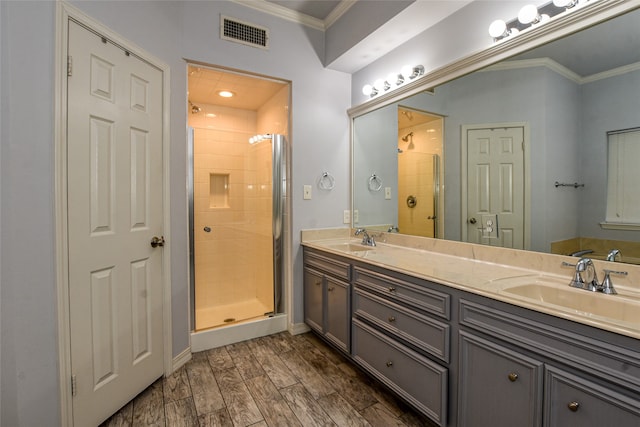 bathroom featuring a shower with door, vanity, ornamental molding, and wood-type flooring