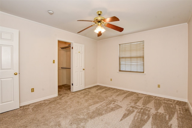 carpeted spare room featuring crown molding and ceiling fan