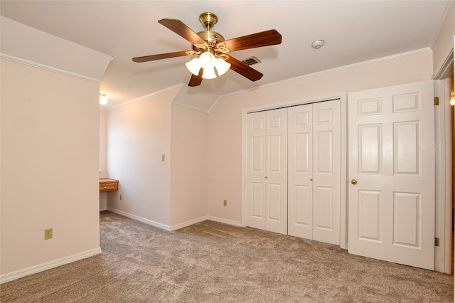 unfurnished bedroom featuring ornamental molding, vaulted ceiling, ceiling fan, and light colored carpet