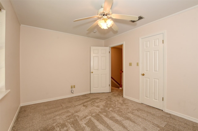 carpeted empty room featuring crown molding and ceiling fan