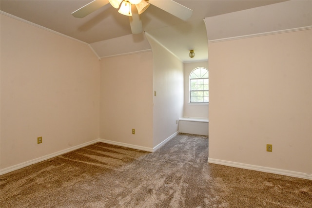 empty room featuring lofted ceiling, ceiling fan, crown molding, and light carpet