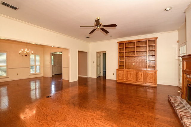 unfurnished living room featuring a fireplace, ceiling fan with notable chandelier, crown molding, built in features, and dark wood-type flooring