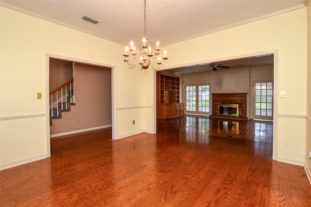 empty room with dark wood-type flooring, ceiling fan with notable chandelier, and ornamental molding