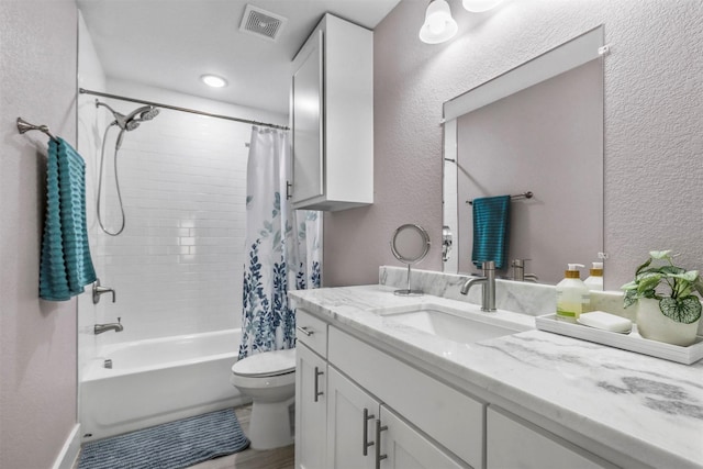 full bathroom with visible vents, a textured wall, toilet, shower / bathtub combination with curtain, and vanity