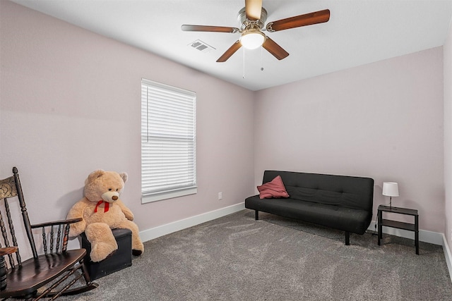 living area with visible vents, dark carpet, baseboards, and ceiling fan