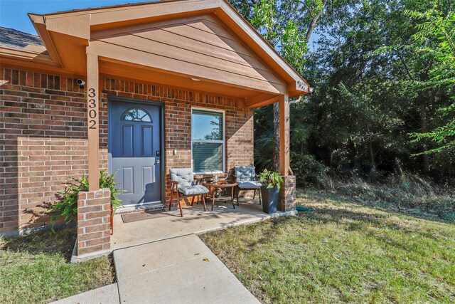 view of exterior entry with a lawn