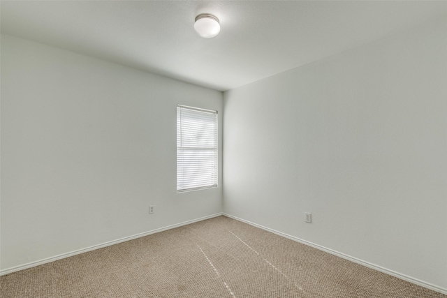 unfurnished room featuring baseboards and light colored carpet