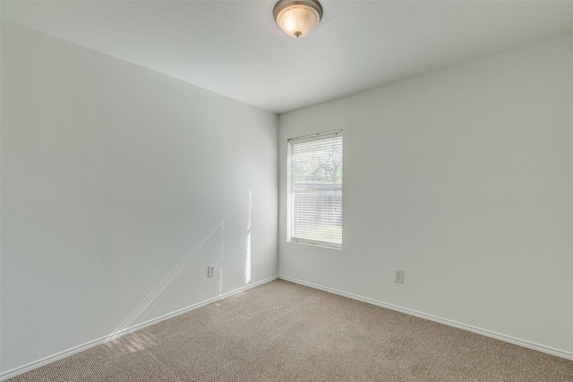 empty room with light carpet and baseboards