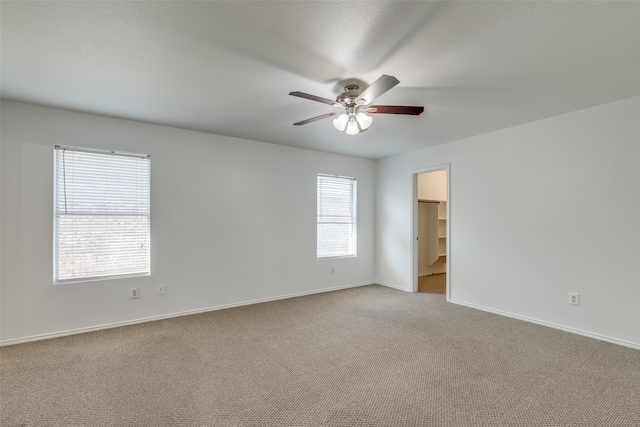 unfurnished room with ceiling fan and light carpet