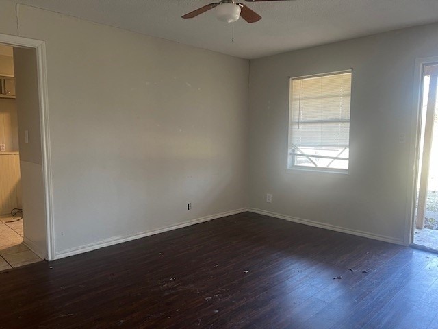 empty room with ceiling fan and dark hardwood / wood-style flooring