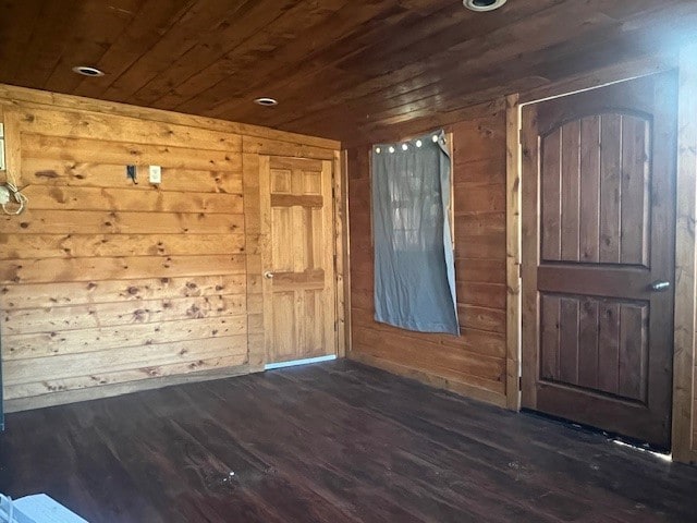 interior space with wooden walls, dark hardwood / wood-style floors, and wooden ceiling