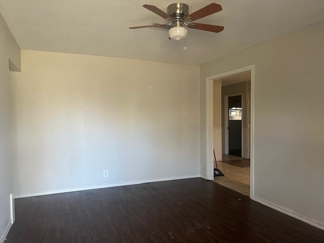 spare room featuring dark wood-type flooring and ceiling fan