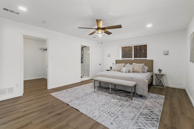 bedroom featuring ceiling fan, a spacious closet, and wood-type flooring