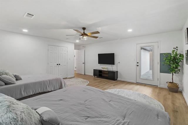 bedroom featuring light wood-type flooring, access to exterior, ceiling fan, and a closet