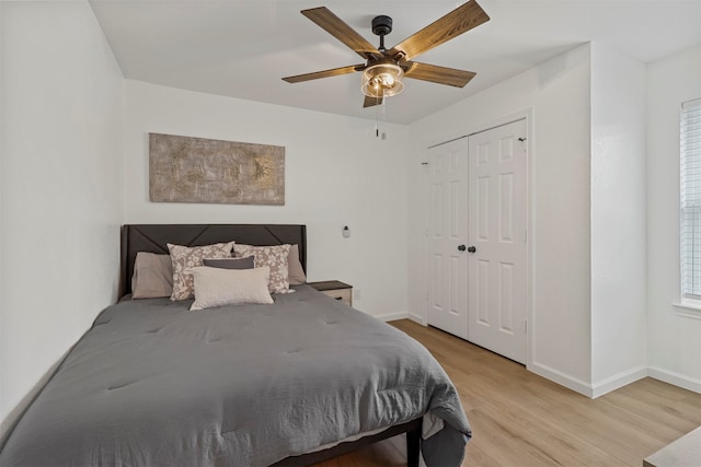 bedroom with light hardwood / wood-style flooring, ceiling fan, and a closet