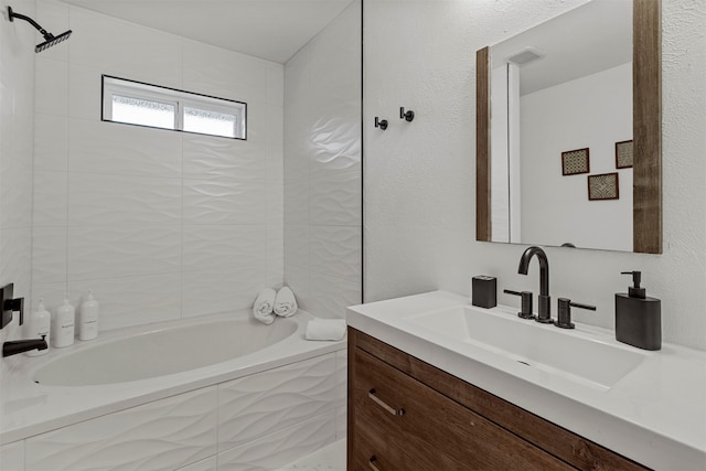 bathroom with tiled shower / bath combo and vanity