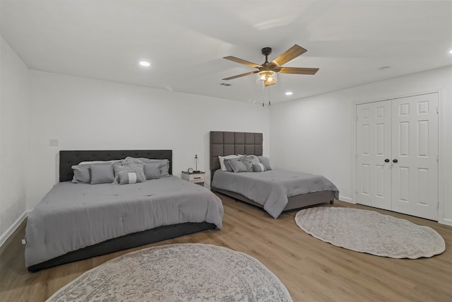 bedroom featuring light hardwood / wood-style flooring, ceiling fan, and a closet