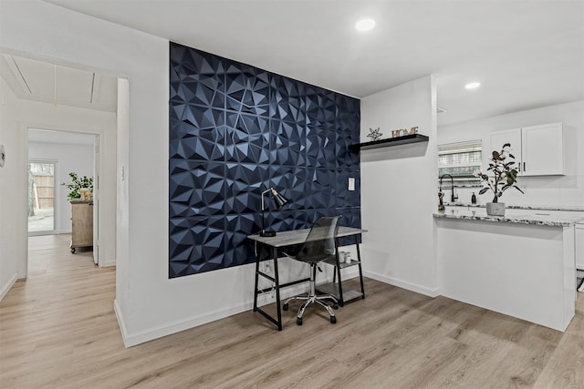 office with light hardwood / wood-style floors and sink