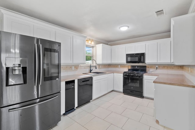 kitchen with ornamental molding, black appliances, sink, and white cabinetry