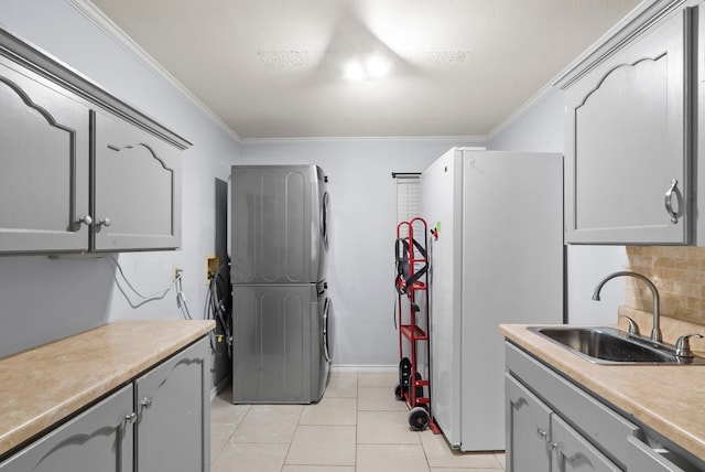 kitchen featuring gray cabinetry, light tile patterned floors, backsplash, crown molding, and sink