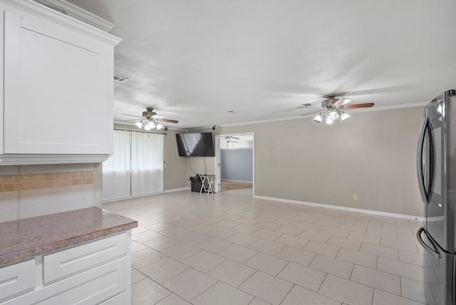 kitchen featuring stainless steel fridge, white cabinetry, crown molding, and ceiling fan