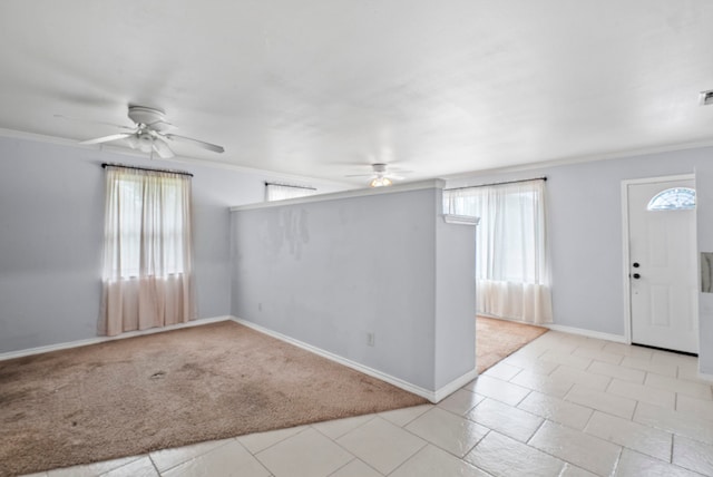 tiled empty room featuring ornamental molding and ceiling fan