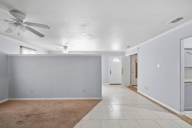 empty room featuring ceiling fan, ornamental molding, and light tile patterned flooring