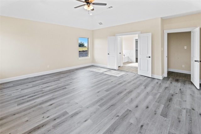 unfurnished bedroom with visible vents, baseboards, wood finished floors, and vaulted ceiling