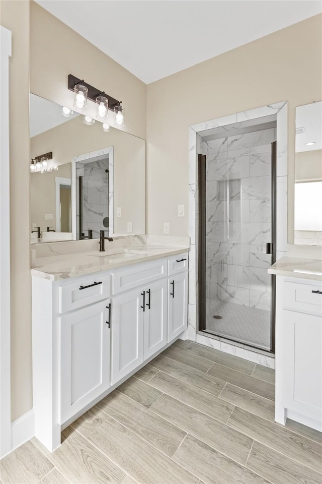 bathroom featuring vanity, a marble finish shower, and wood tiled floor