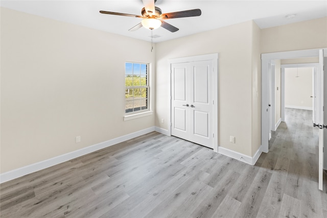 unfurnished bedroom with ceiling fan, a closet, and light hardwood / wood-style floors