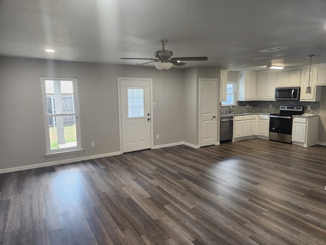 kitchen featuring pendant lighting, white cabinetry, dark hardwood / wood-style flooring, ceiling fan, and appliances with stainless steel finishes