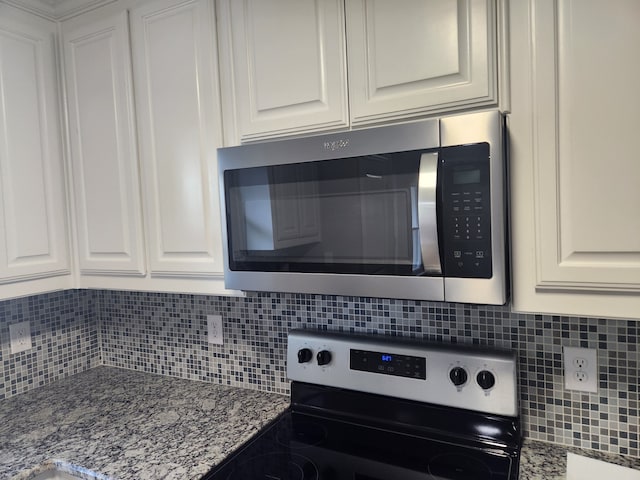 kitchen with tasteful backsplash, electric stove, white cabinetry, and stone counters