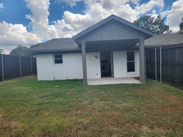 back of property featuring a patio area and a lawn