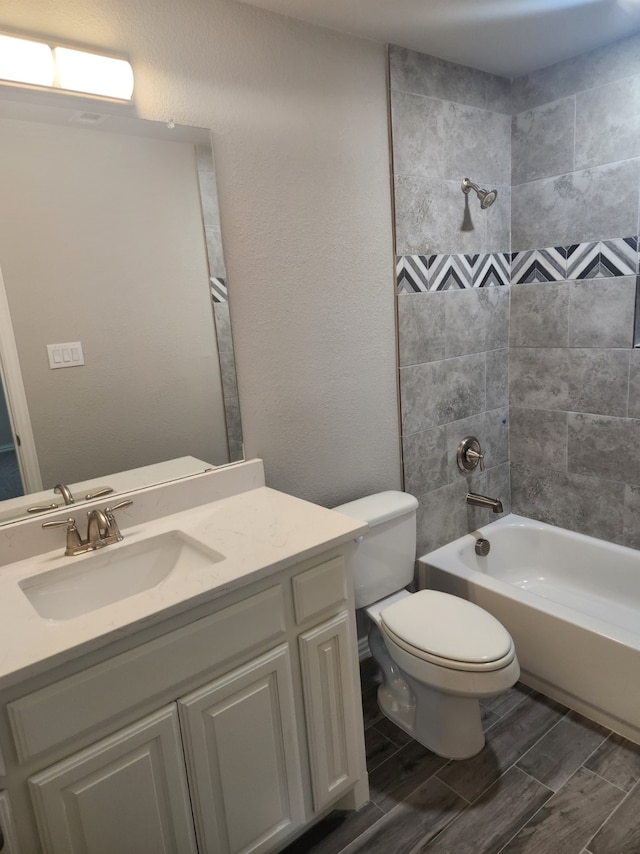 full bathroom with tiled shower / bath combo, vanity, and toilet