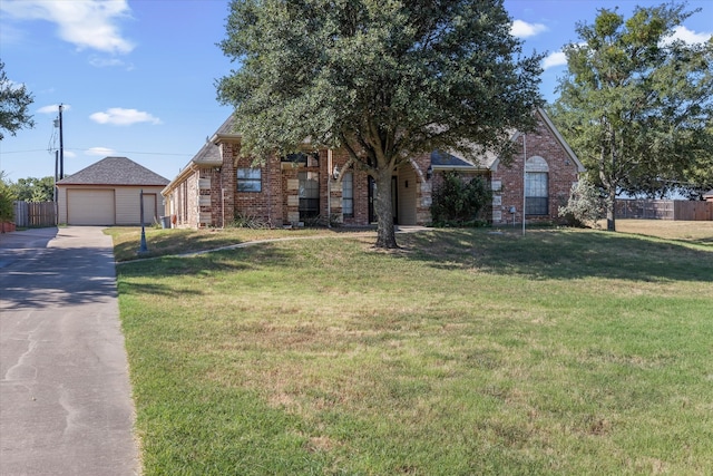 view of front of house featuring an outdoor structure, a garage, and a front lawn