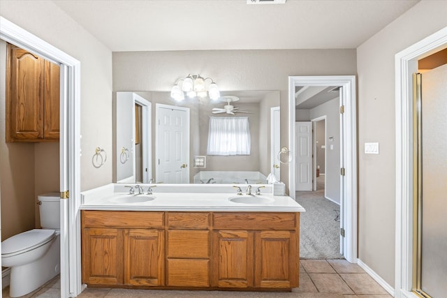 bathroom featuring tile patterned flooring, toilet, a shower with door, and vanity