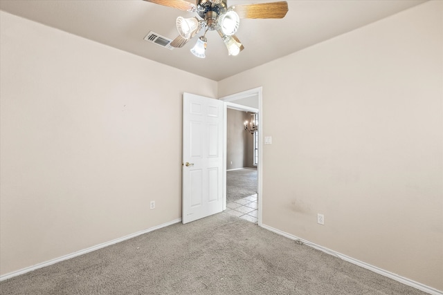 spare room with ceiling fan and light carpet