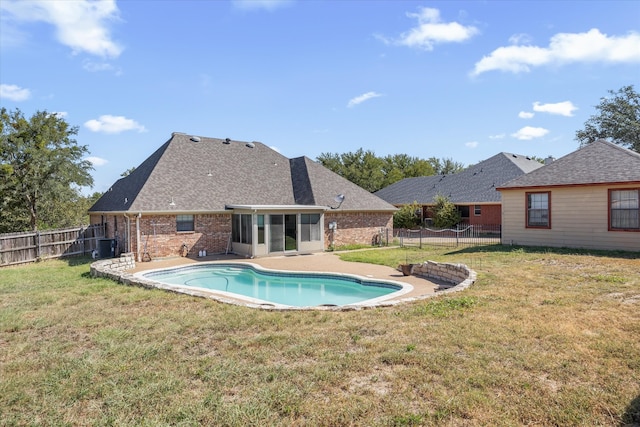 view of swimming pool featuring a patio area, a yard, and cooling unit